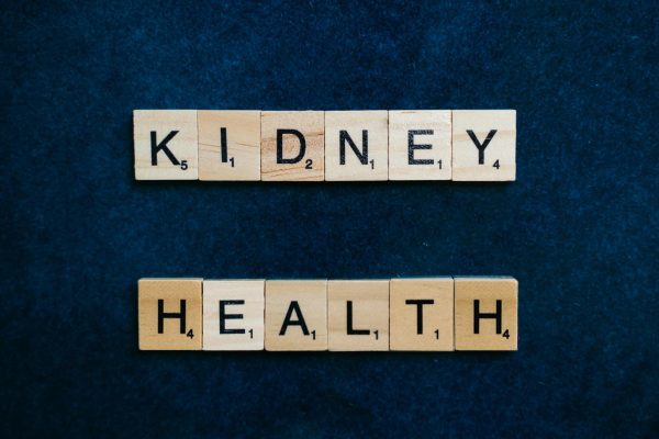 Scrabble tiles spelling “KIDNEY HEALTH” on a dark blue background.
